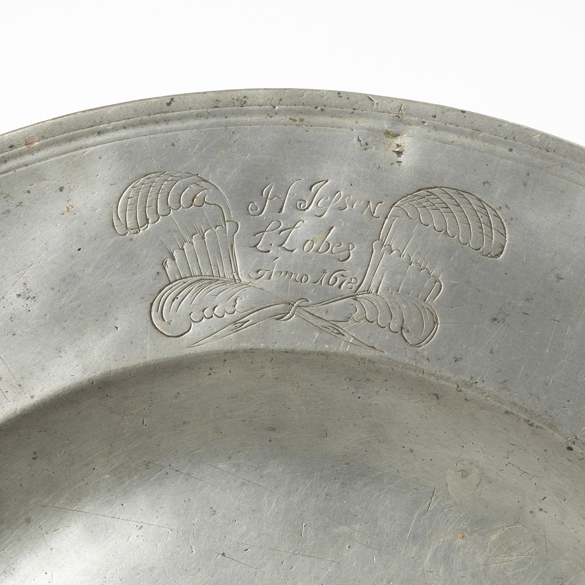 An English baroque pewter charger, dated 1672.