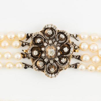 Multi-strand pearl necklace with a clasp/brooch in gold with diamonds,.