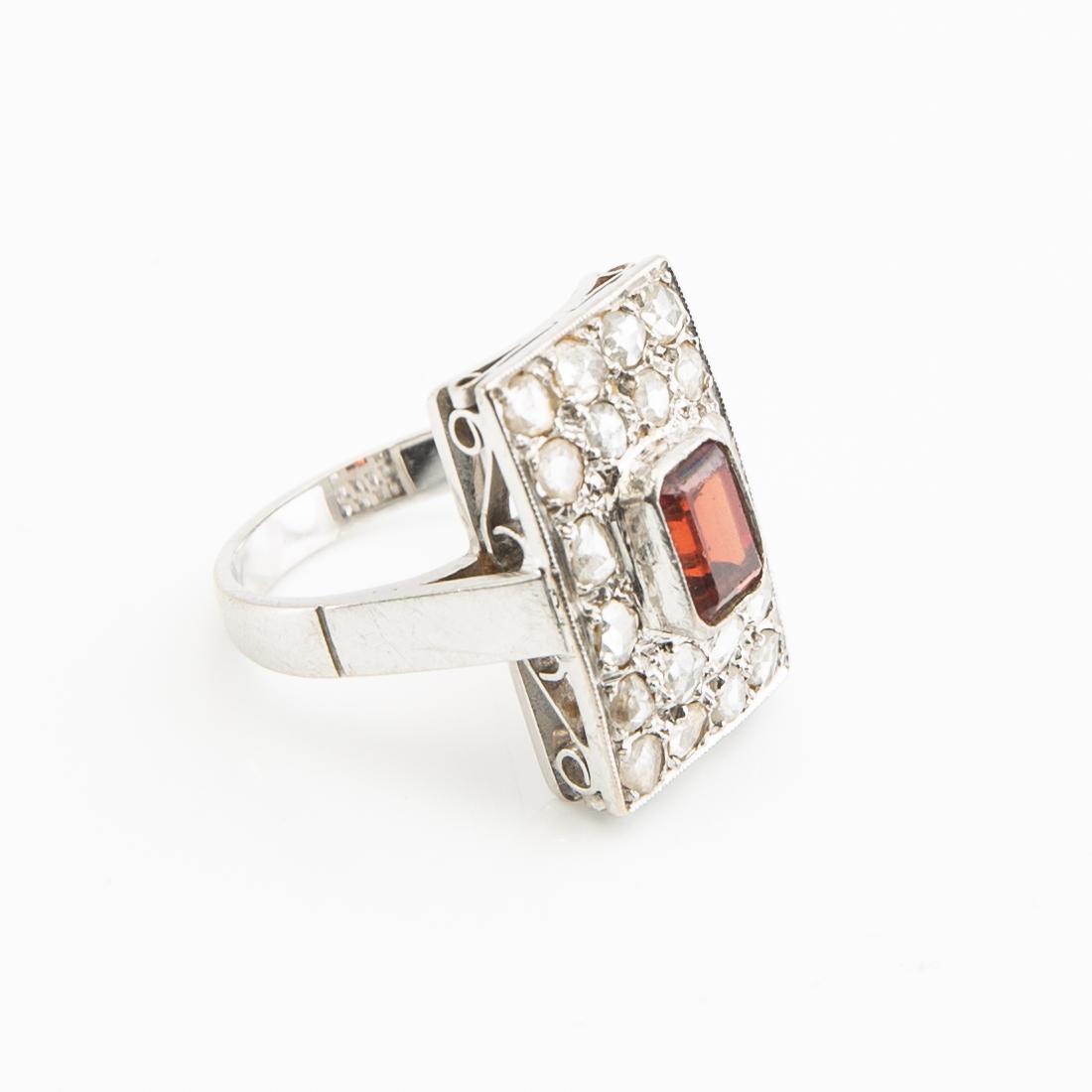 Ring, 18K white gold with a red stone (possibly garnet) and diamonds.