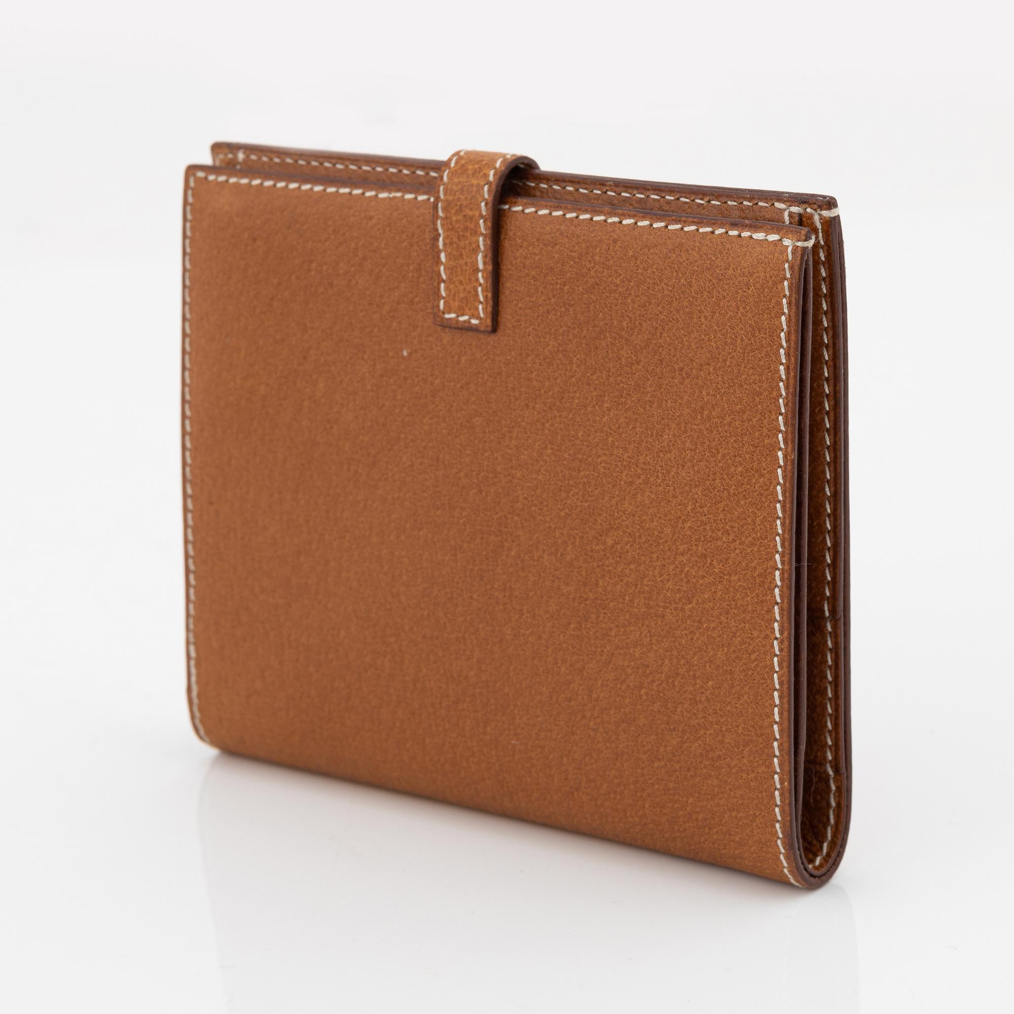Hermès, a brown leather gold lock wallet.