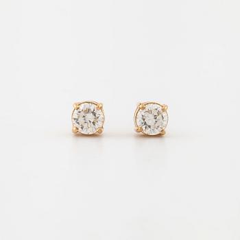 A pair of brilliant cut diamond earrings.