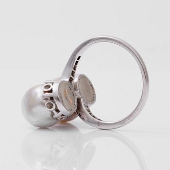 A ring set with a pair of semi baroque natural saltwater pearls and old-cut diamonds.