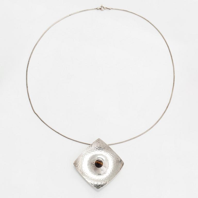 Elis Kauppi, a silver brooch/pendant, and tiger's eye. Kupittaan Kulta, Turku 1962.