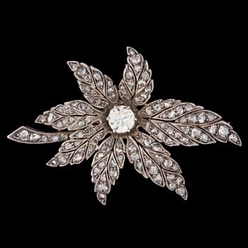 1210. An antique- and rose cut diamond brooch of floral design, center stone app. 1.10 ct.