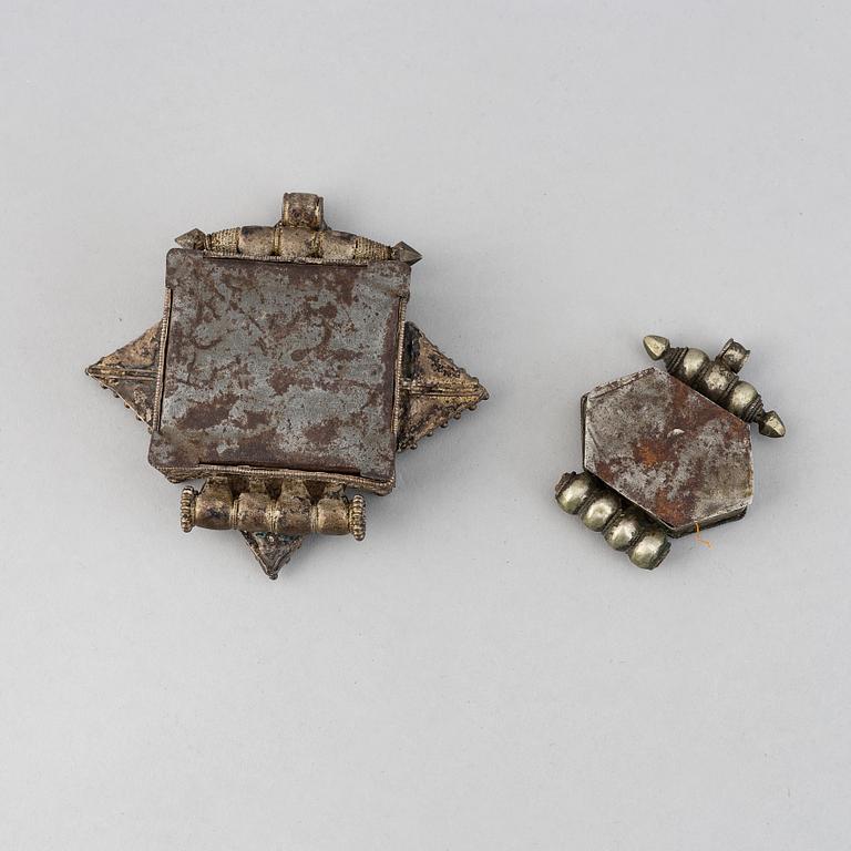 Two metal pendants with turkoise inlay, Tibet, circa 1900.