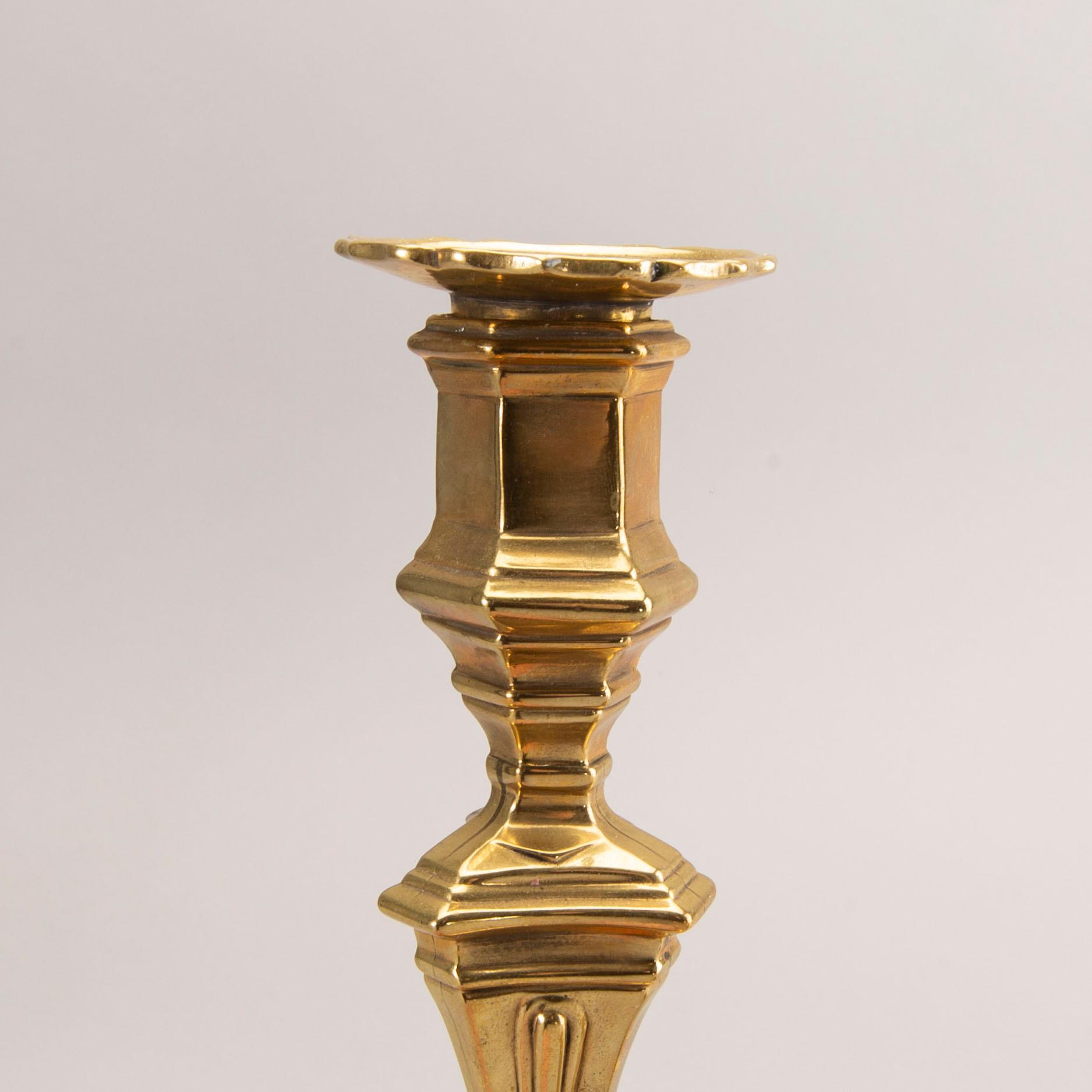 A pair of rococo brass candlesticks, possibly France.
