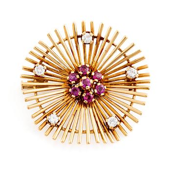 An 18K gold brooch set with round brilliant-cut diamonds and rubies.