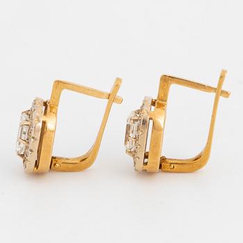 A pair of earrings in 18K gold set with emerald-cut diamonds.