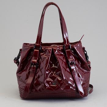 A darkred lacquer leather handbag by Burberry Prorsum.