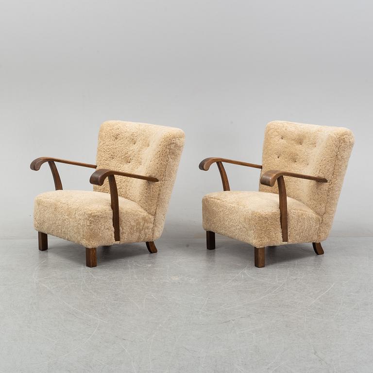 A pair of Danish lounge chairs with sheepskin upholstery.