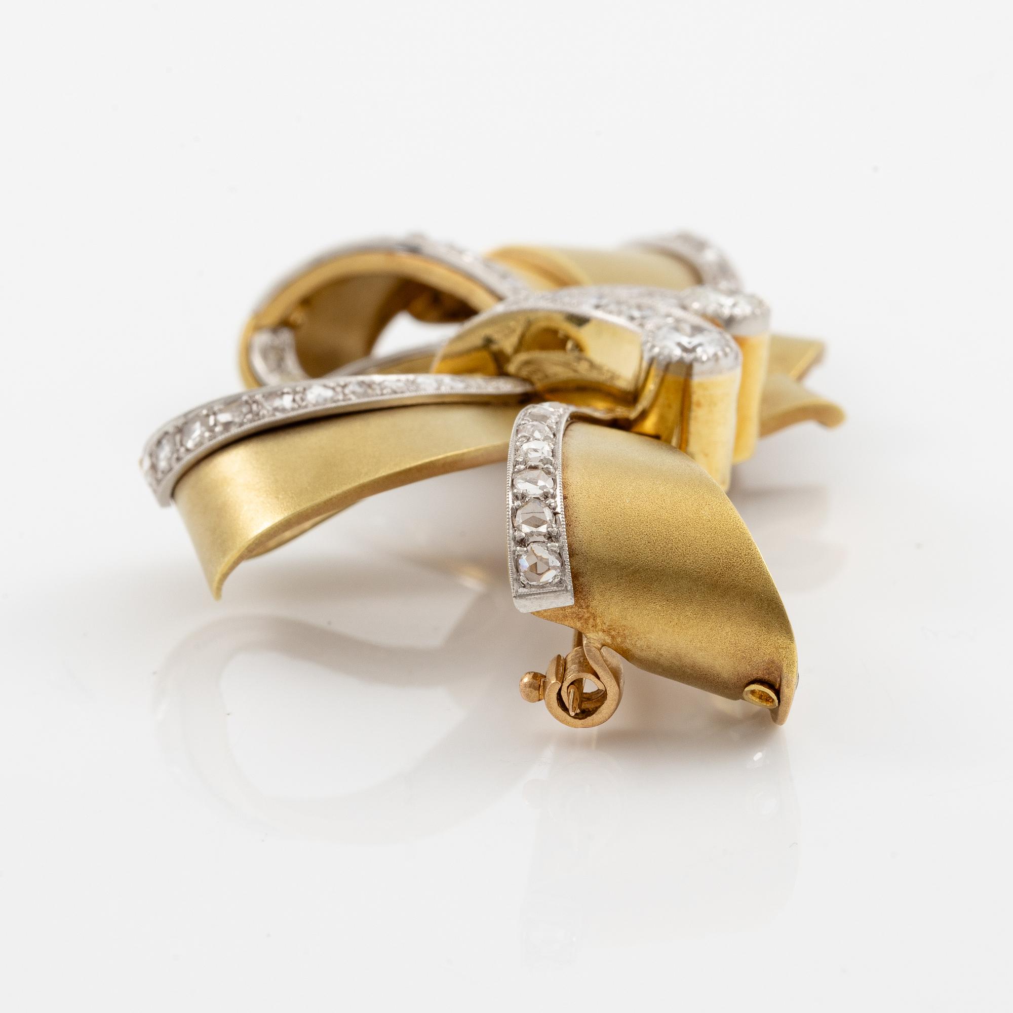 Bow brooch in 18K gold and platinum set with round brilliant, eight-cut, and rose-cut diamonds.