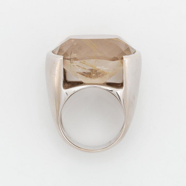 A Tina Karlsson ring in 18K white gold ring set with a faceted rutile quartz.