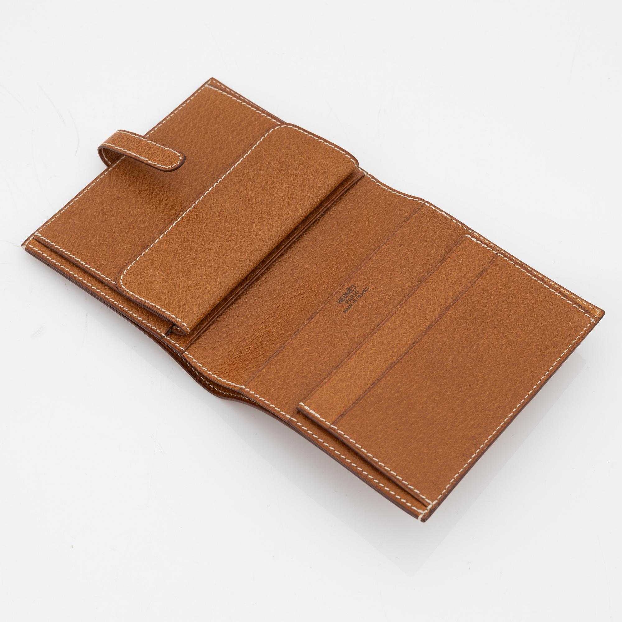 Hermès, a brown leather gold lock wallet.