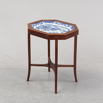 A mahogany veneered table with a Chinese blue and white porcelain charger, Qianlong (1736-95).