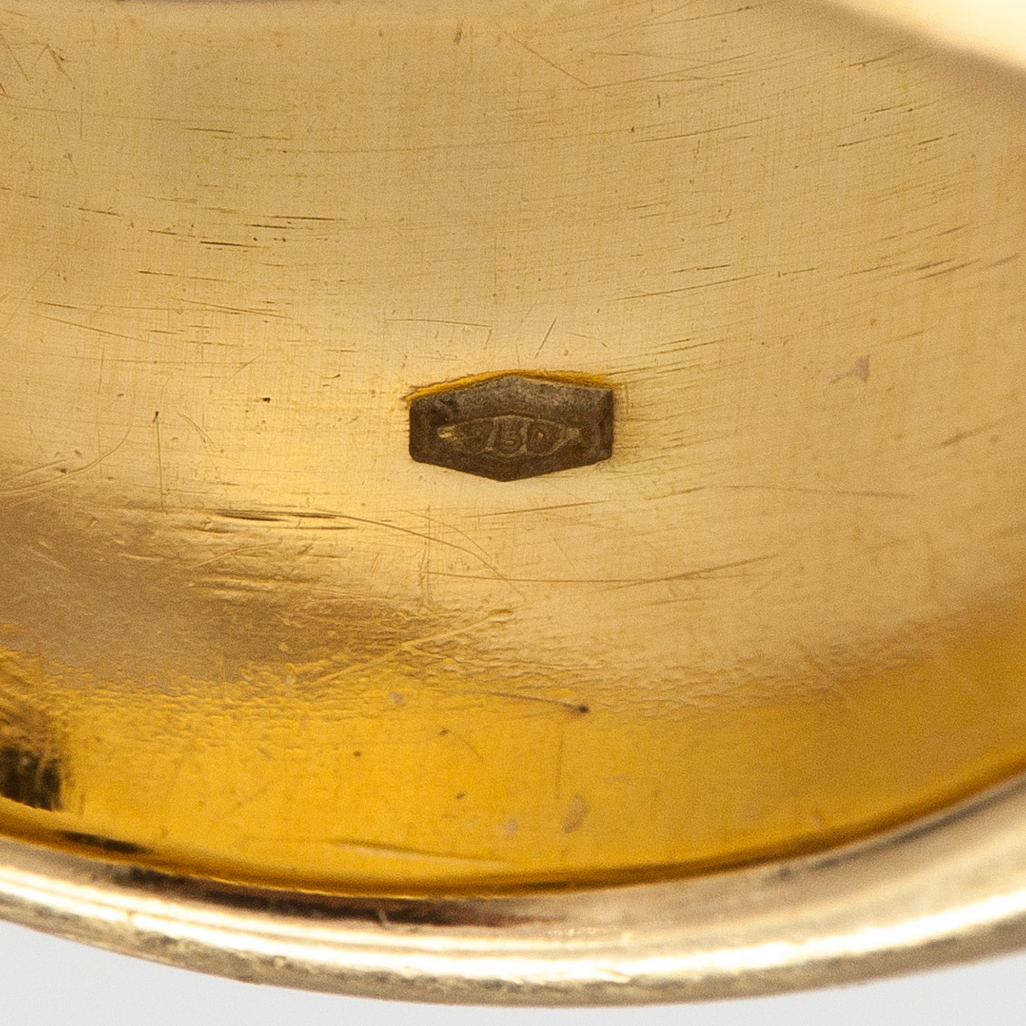 An 18K gold ring with rubies and sapphires. Import marked Torbjörn Tillander, Helsinki 1991.
