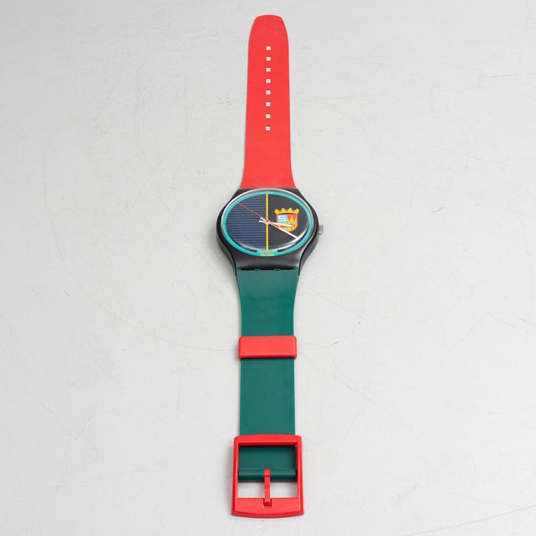 A wall clock, Swatch.
