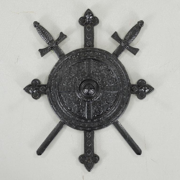 A decorative cast iron shield, around the year 1900.