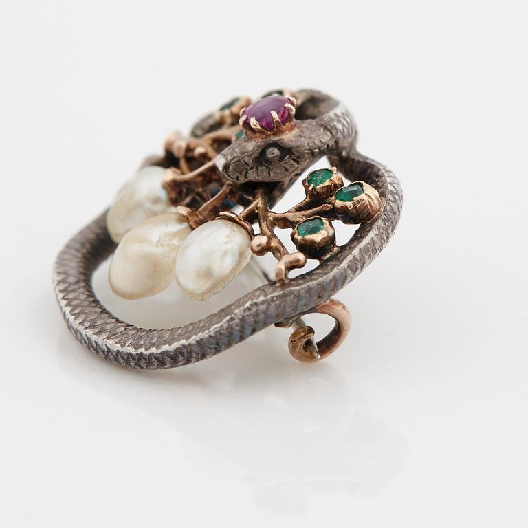 A Karl Rothmüller, Art Nouveau serpent brooch, circa 1900, with a ruby, emeralds and probably natural saltwater pearls.