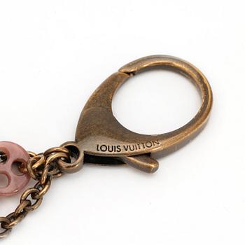 LOUIS VUITTON, a brass bag charm.