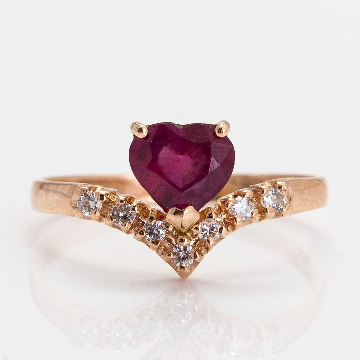 A 14K gold ring, with a heart-shaped ruby and diamonds.