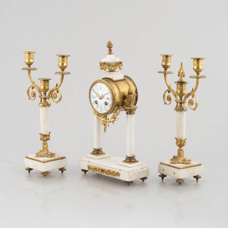 A Louis XVI-style mantel clock Paris, France and a pair of candelabras, late 19th century.