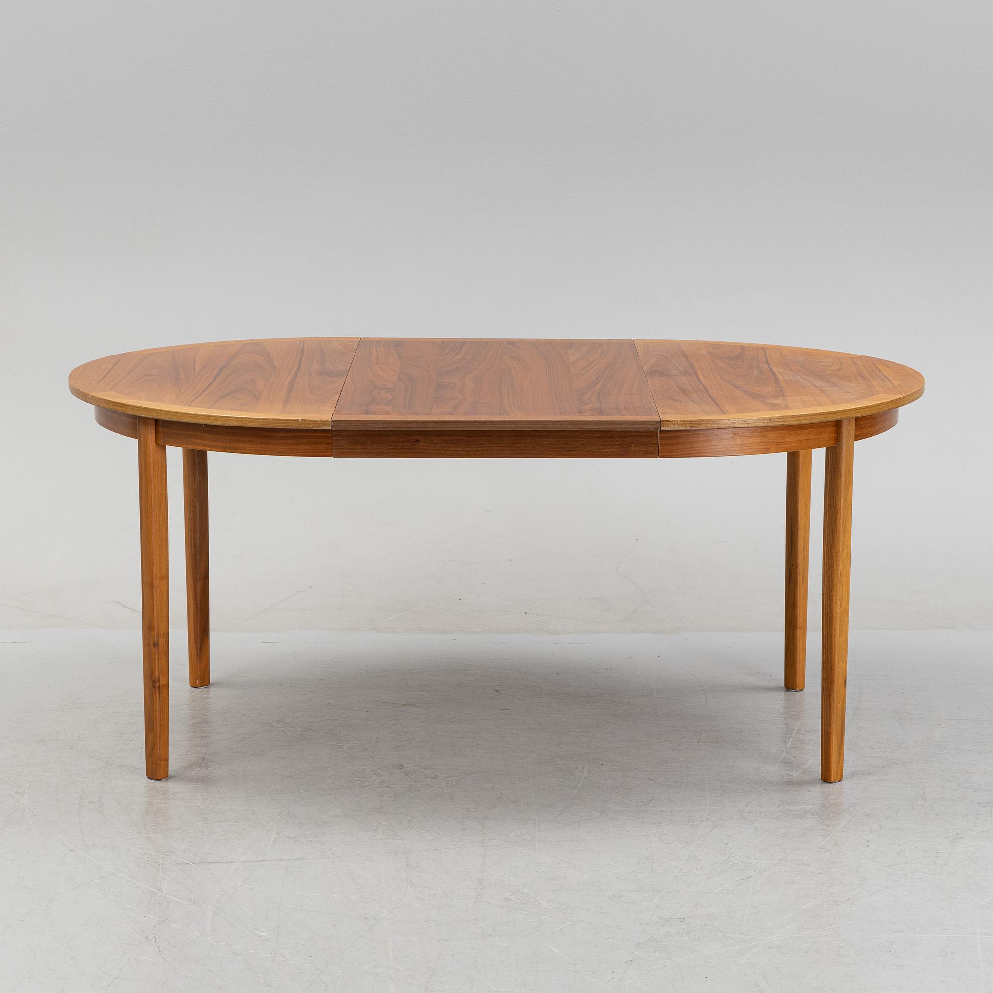 A round walnut veneered dining table.