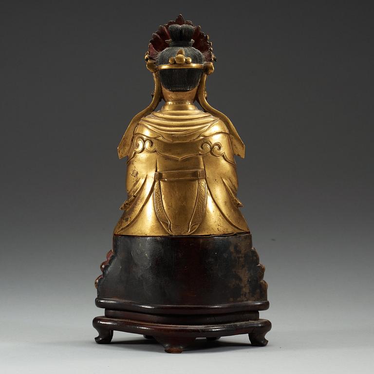 A gilt bronze figure of a sitting female deity, Qing dynasty, 18th Century.