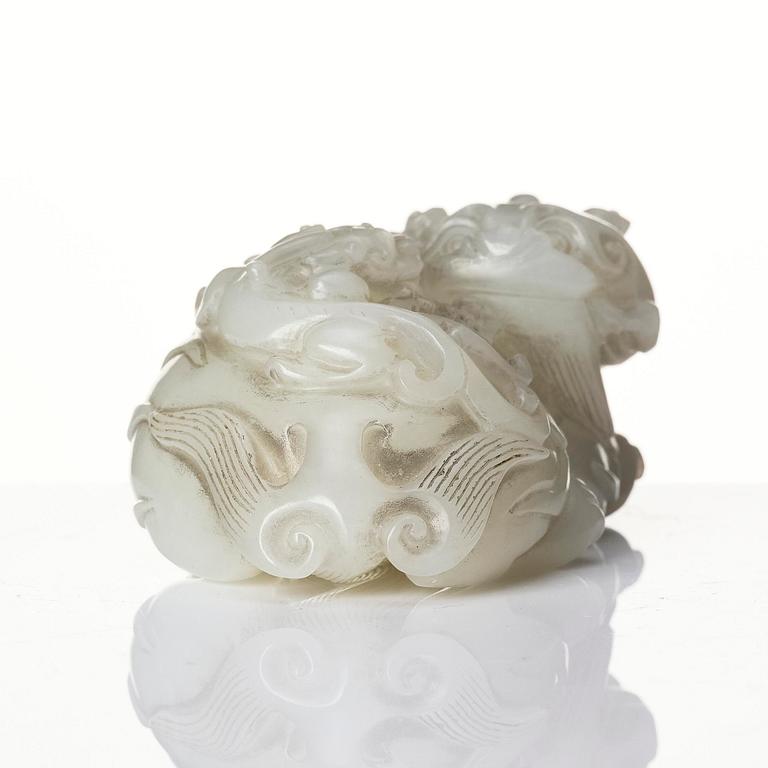 A Chinese nephrite carving of a recumbant lion with her cub, Qing dynasty.