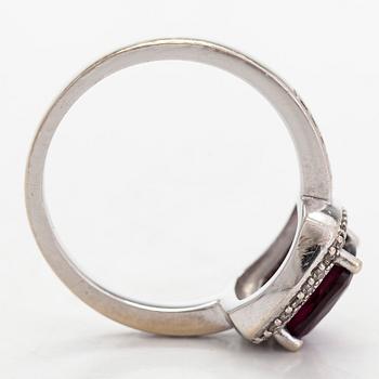 A 14K gold ring, with diamonds totalling approximately 0.095 ct and a garnet.