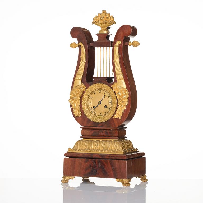 A French Empire mahogany, ormolu and gilt metal lyre-shaped mantel clock, early 19th century.