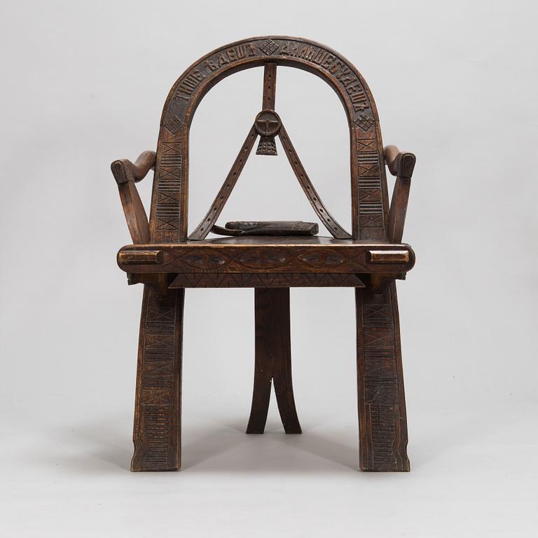 A carved oak wood armchair after V.P. Shutov's design "Arch, axe and gloves", Russia, late 19th century.