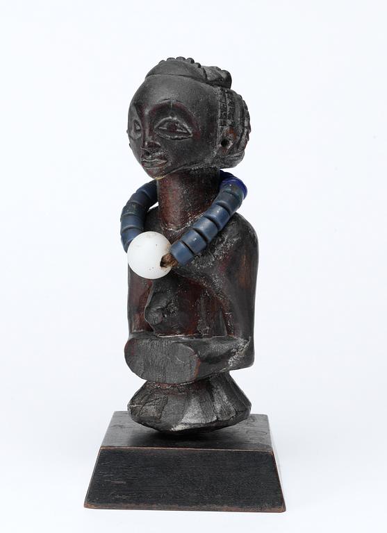 FETISCH. Trä med halsband av glaspärlor. Luba-stammen. Kongo omkring 1900. Höjd 18 cm.