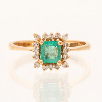 Ring in 18K gold with a step-cut emerald and round brilliant-cut diamonds.