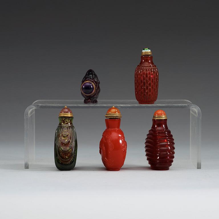 A group of five Chinese snuff bottles with stoppers.