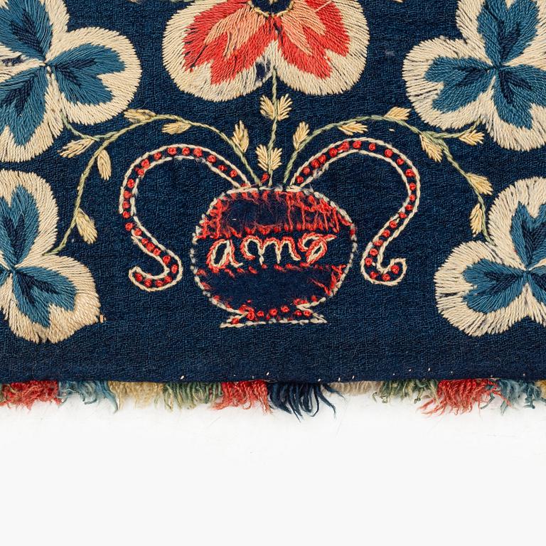 An embroidered carrige cushion, ca 108 x 48 cm, signed AMA, Scania, first half of the 19th century.