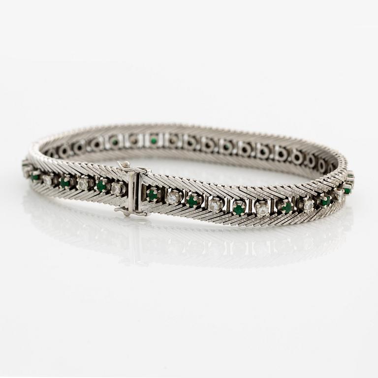 Bracelet 18K gold with round brilliant-cut diamonds and green stones, likely emeralds.