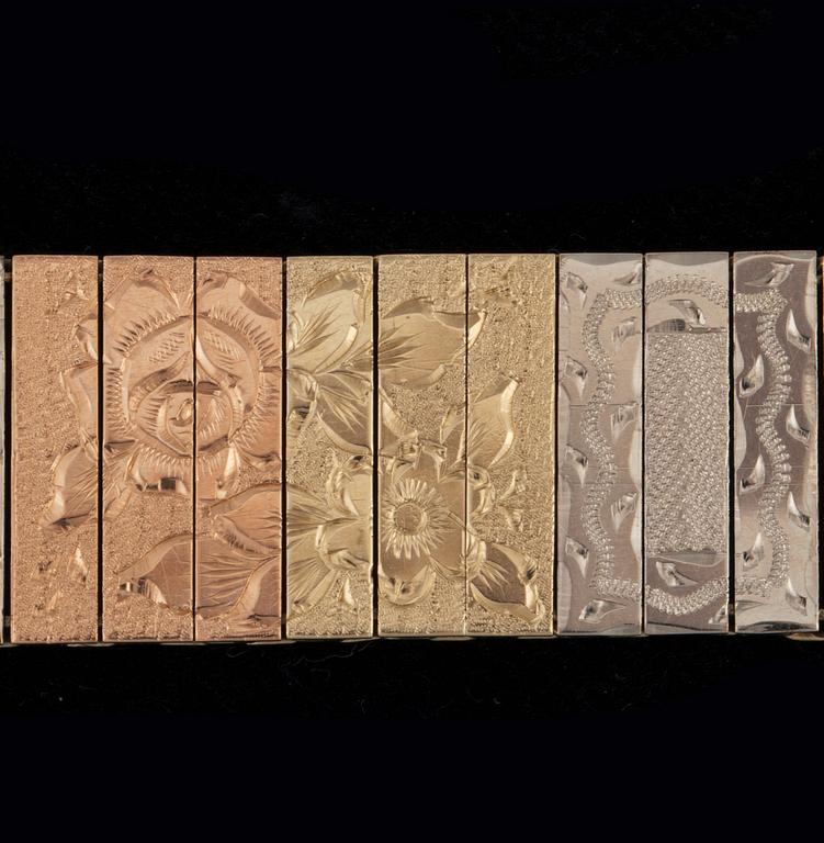 A tricoloured gold bracelet with flower motifs.