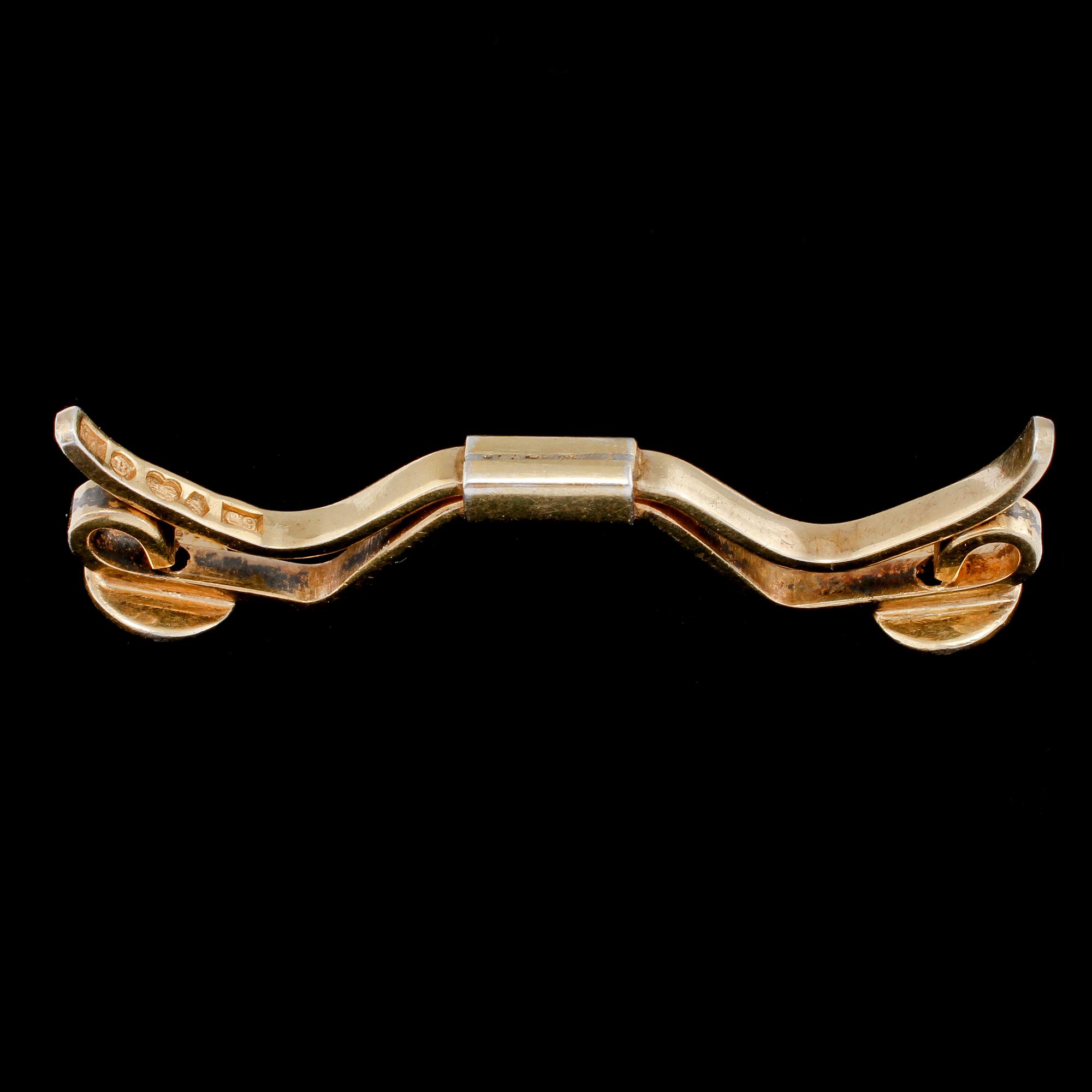 SPÄNNE, 18k guld med 2 briljantslipade vita stenar, Nils Ahlström, Borås, 1953. Vikt 6 g.