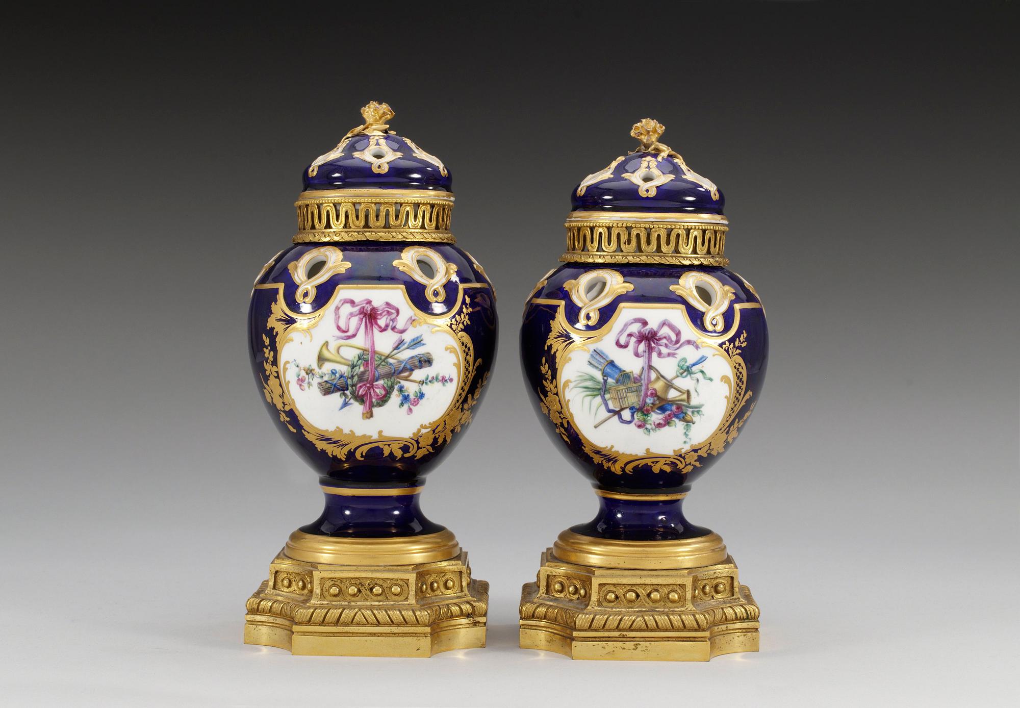 A pair of gilt bronze mounted Sevres pot-pourri jars with covers, 18th Century. (2).
