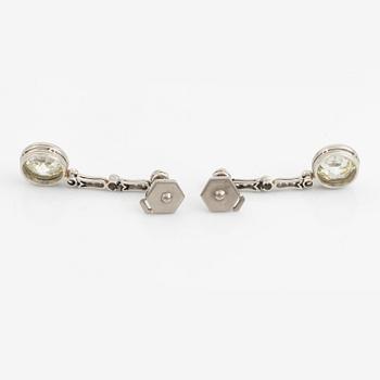 A pair of platinum earrings with two larger old-cut diamonds.