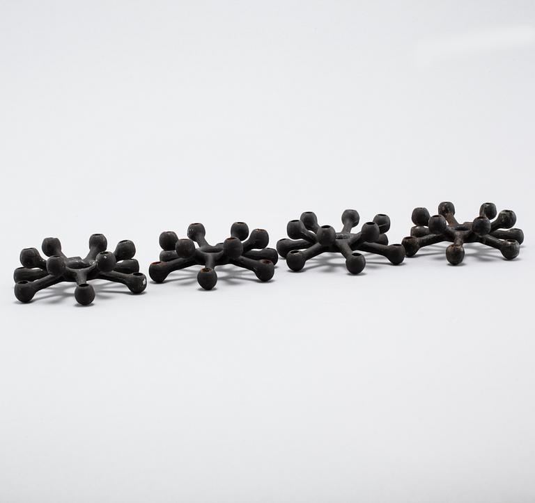 Four 1960s iron cast candle holders, designed by Jens Quistgaard for Dansk Designs .