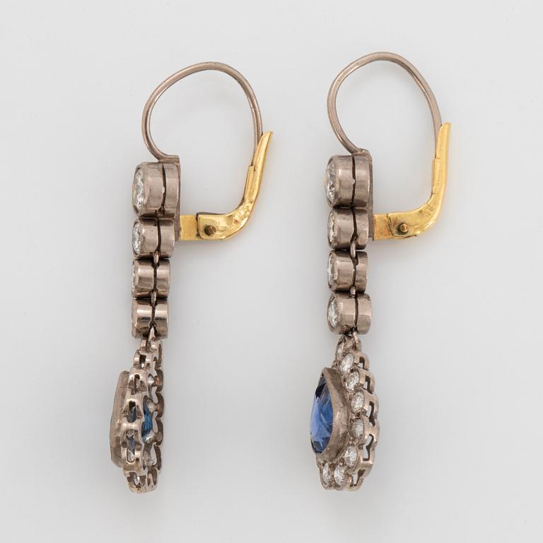 A pair of platinum and 14K gold earrings set with faceted sapphires and old-cut diamonds.