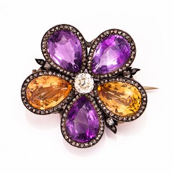 A silver and gold brooch with three amethysts, two citrines, one old cut diamond ca 0.7 ct and rose cut diamonds.