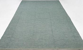 A "Dogtooth metallic green" carpet, Vandra rugs, c. 562 x 265 cm.