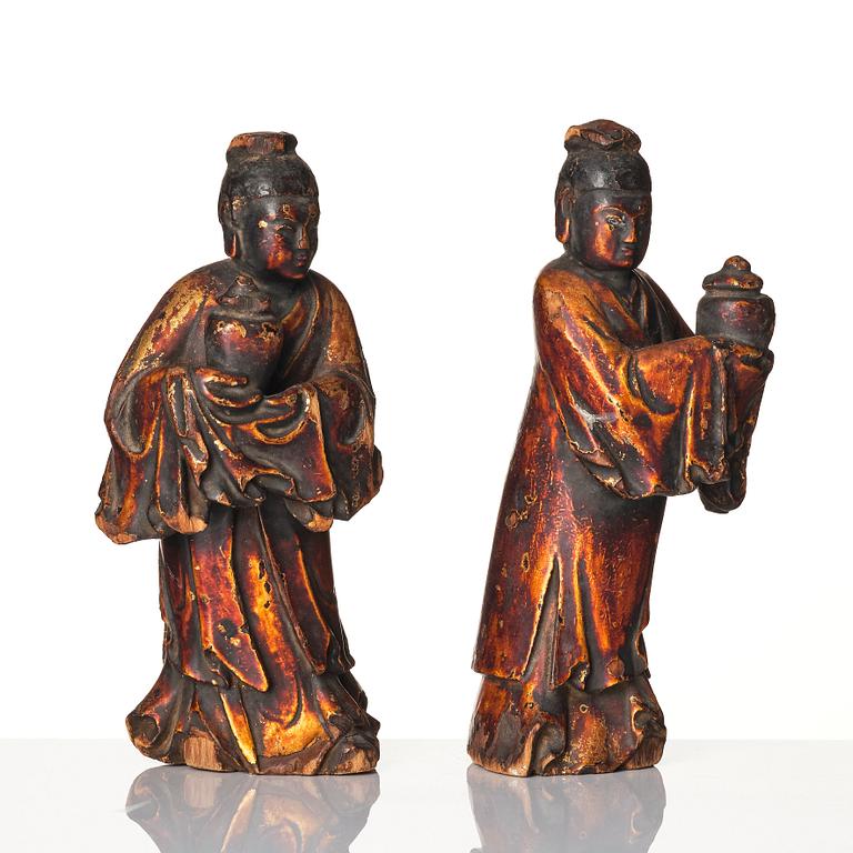 A pair of wooden gilt lacqer figures of officials carrying vases, 17/18th century.