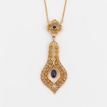 A necklace set with seed pearls, a cabochon cut sapphire, probably another sapphire and filigree work.