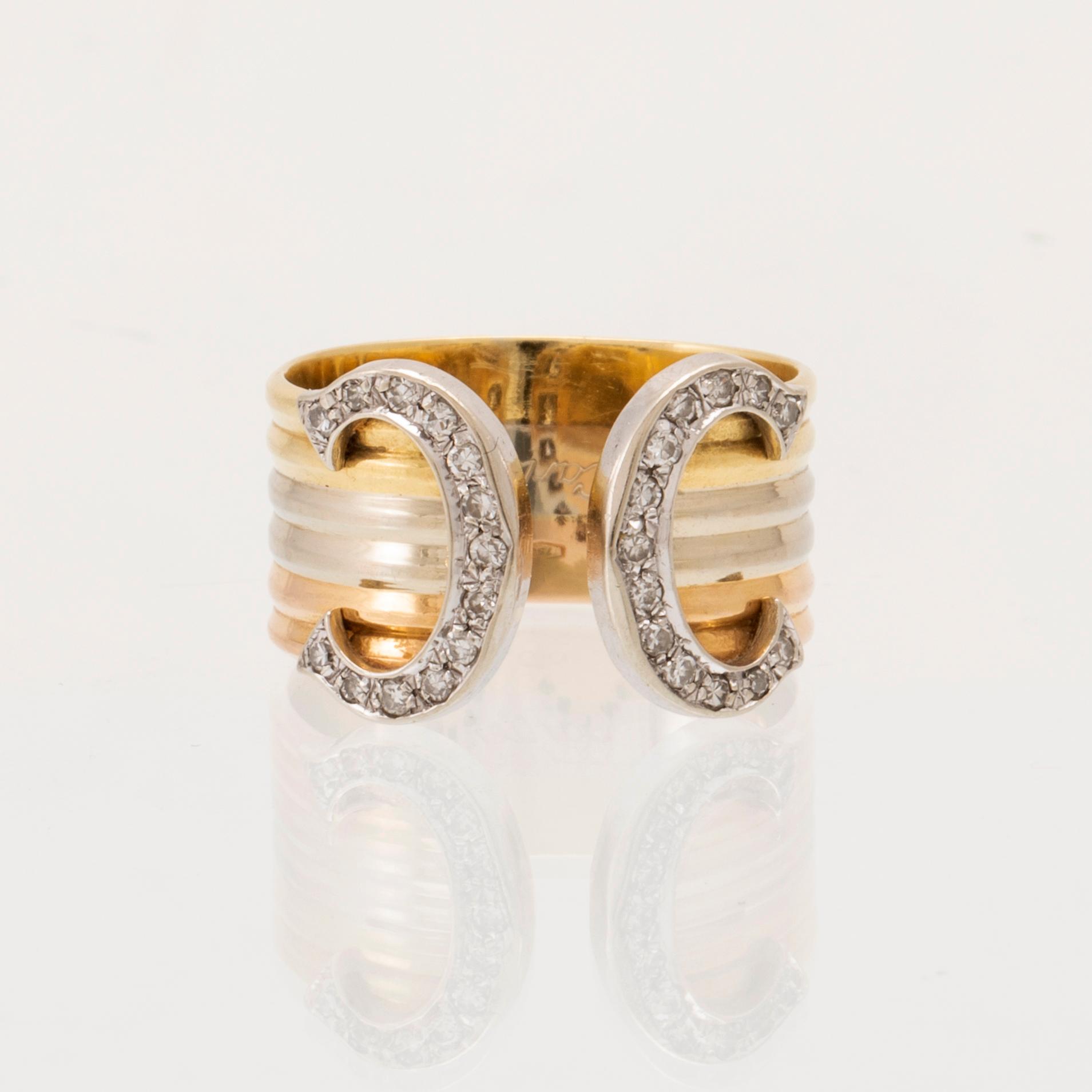 A Cartier "Double C" ring 18K tricolor gold set with round single-cut diamonds.