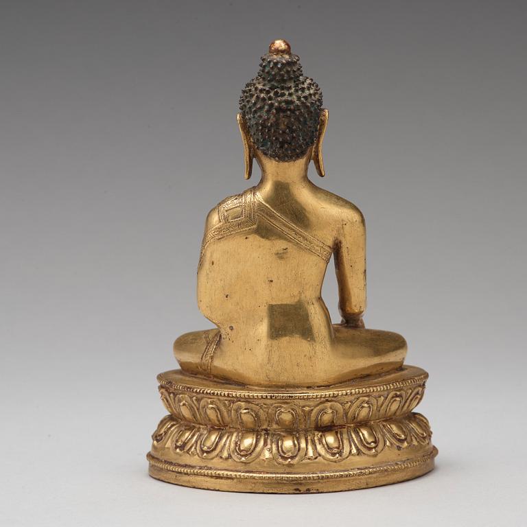 A gilt copper alloy figure of Akshobhya, Tibet, 16th Century.