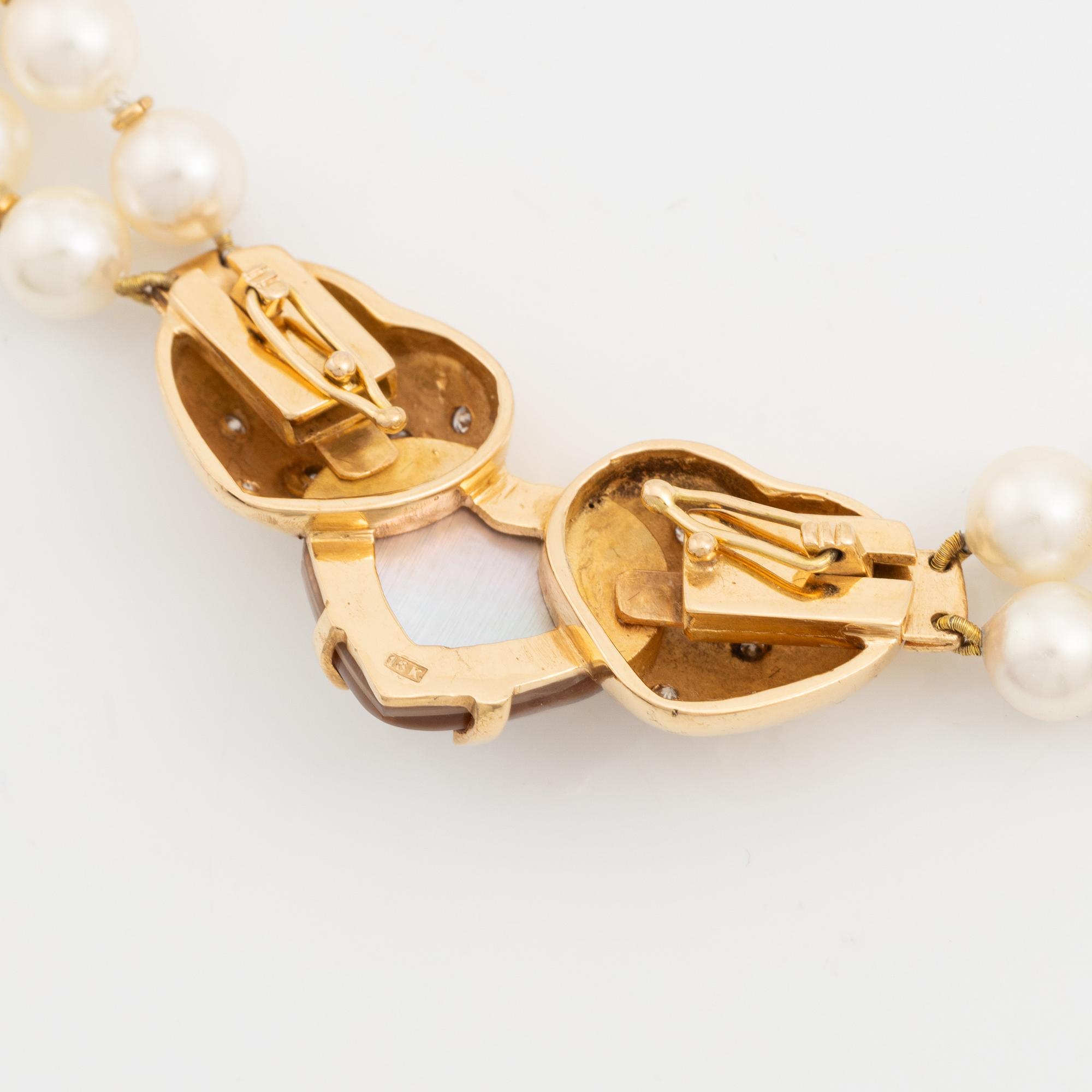 A two strand cultured pearl necklace with an 18K gold clasp with a half-pearl and round brilliant-cut diamonds.