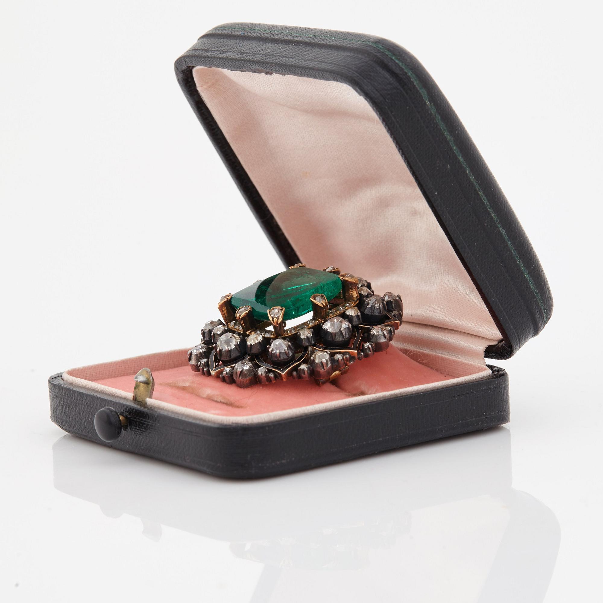 An emerald, black enamel and old cut diamond brooch. 19th century.